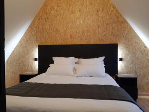 a bedroom with a large bed with a black headboard at Éco-domaine Gîtes et Spa - Mer, Nature & Confort - Côte d'Opale in Wierre-Effroy +24 photos