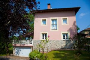 une maison rose avec un mur en pierre dans l'établissement Villa Mercedes, à Piloña
