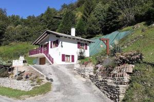 una piccola casa bianca su una collina con dei fiori di Gîte de campagne a Rosureux