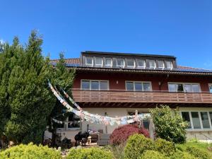a building with a string of flags in front of it at Landhaus Bukenberger in Freudenstadt +17 photos
