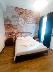 um quarto com uma cama e uma parede de tijolos em Skyline #Downtown em Civitavecchia