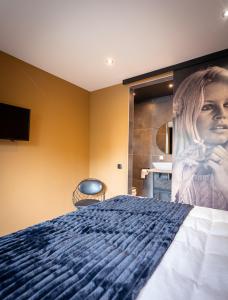 a bedroom with a bed with a painting on the wall at B&B Bardot in Purmerend