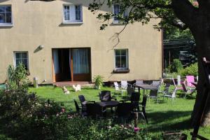 a yard with tables and chairs in front of a building at Zagroda Agroturystyczna Wiecha in Mieroszów