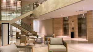 a lobby with chairs and a staircase in a building at Kawana Golf Residence in Cikarang