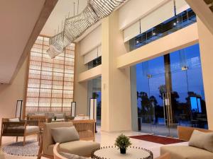 a lobby with chairs and tables and a large window at Kawana Golf Residence in Cikarang