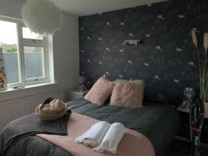 a bedroom with a bed with a black and pink wallpaper at Shore Lodge. 4 bed bungalow only mtrs from the beach. Sleeps 8 in Sutton on Sea