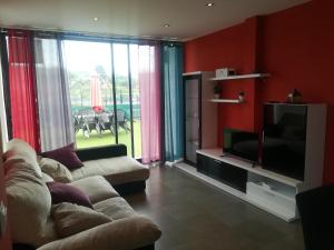 a living room with a couch and a flat screen tv at Villa Dalia in Suances