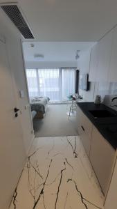 a kitchen with a marble floor and a kitchen with a sink at Lividus 432 By Edyta in Świnoujście +3 photos