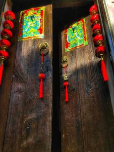 three red tassels on a wooden table with windows at Qu Hi Home Stay in Jiufen