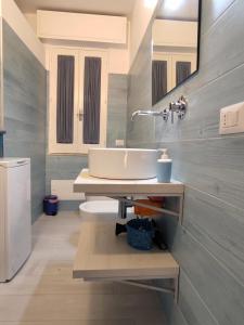 łazienka z białą umywalką i lustrem w obiekcie Blue Moon Apartments w mieście Capo dʼOrlando