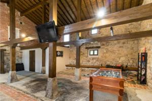 - un salon avec une télévision sur un mur en pierre dans l'établissement Espectacular villa rural en Cabárceno, à Penagos