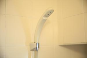 une brosse à dents blanche accrochée au mur dans la salle de bains. dans l'établissement 【渋谷35】光回線完備のお部屋＜Rewrite＞, à Tokyo