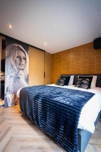 a bedroom with a large bed with a blue blanket at B&B Bardot in Purmerend