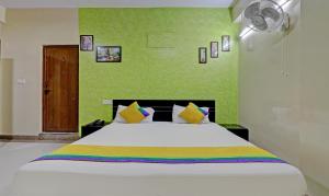 a bedroom with a large white bed with green walls at Itsy By Treebo - Palm Emirates in Bangalore