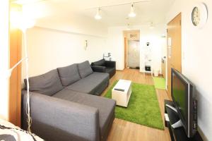 a living room with a couch and a tv at 【渋谷35】光回線完備のお部屋＜Rewrite＞ in Tokyo