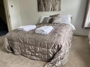 a bedroom with a bed with a gray comforter at 4 Bedroom House in Harrogate Town Centre in Harrogate
