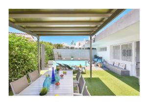 un patio con mesa y sillas junto a una piscina en Beach House Top ET 1 by VillaGranCanaria en San Agustín