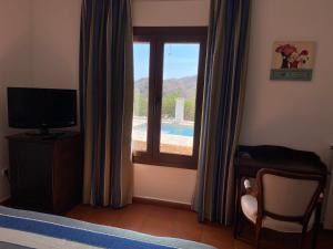 モハカルにあるCasa Rural Mi Abuela Mariaのベッドルーム1室(プールの景色を望む窓付)
