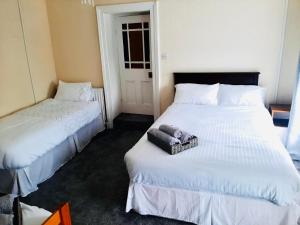 Habitación de hotel con 2 camas y toallas. en Railway Bar Accommodation en Poyntz Pass