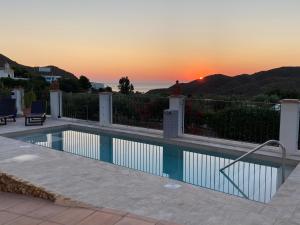 a swimming pool with a sunset in the background at Casa Rural Mi Abuela Maria in Mojácar