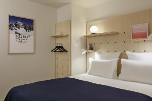 a bedroom with a bed with white pillows at Appart'hôtel Bellamy Chamonix in Chamonix-Mont-Blanc +66 photos