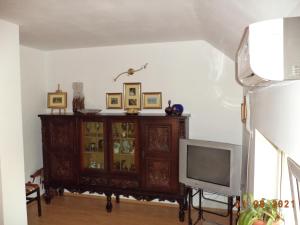 una camera con TV e armadietto con porte in vetro di vila Irina a Constanţa