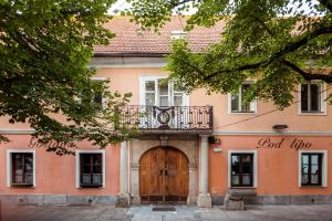 a pink building with a wooden door and a balcony at Penzion Pod Lipo in Ljubljana