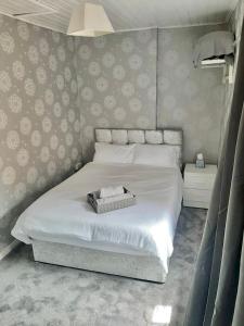 een slaapkamer met een groot bed met witte lakens bij Railway Bar Accommodation in Poyntz Pass