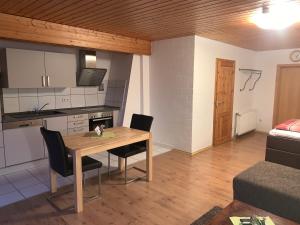 - une cuisine et une salle à manger avec une table et des chaises dans l'établissement Gästezimmer & Appartement Elskop, à Elskop