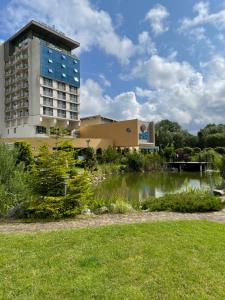 科沃布热格ARKA APARTAMENT DELUXE 723b的建筑物前有池塘的建筑物