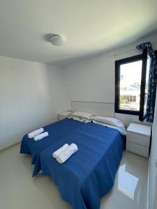 a bedroom with a blue bed with two towels on it at Corralejo Oasis in Corralejo