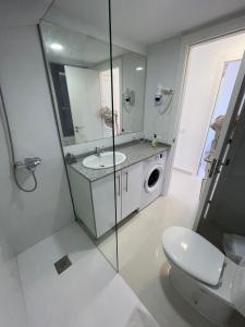 ein Badezimmer mit einem WC, einem Waschbecken und einem Spiegel in der Unterkunft Corralejo Oasis in Corralejo