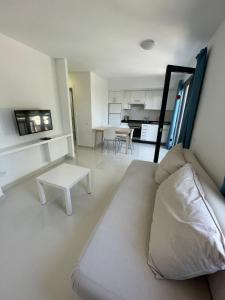 a white living room with a couch and a table at Corralejo Oasis in Corralejo