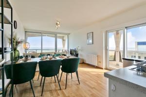 a kitchen and living room with a table and chairs at Flat Marie in De Panne