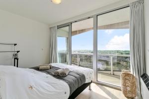 a bedroom with a bed and a large window at Flat Marie in De Panne