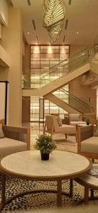 a lobby with a table and chairs and stairs at Kawana Golf Residence in Cikarang