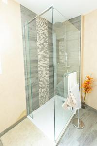 La salle de bains est pourvue d'une douche avec une porte en verre. dans l'établissement Cannarozzo, à Sausset-les-Pins