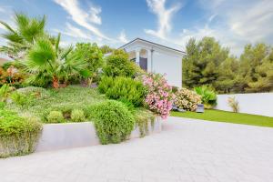 une maison avec un jardin planté de plantes et d'arbres dans l'établissement Cannarozzo, à Sausset-les-Pins