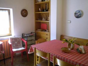 una sala da pranzo con tavolo e tovaglia rossa di House Casa Defrancesco a Moena