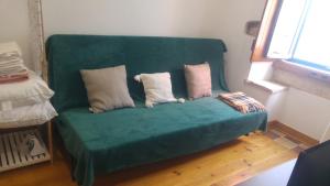 a green couch with three pillows on it in a room at Lisbon Rossio Typical Apartments in Lisbon