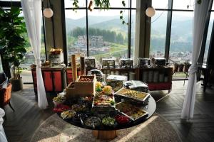 a buffet of food on a table in a room with windows at Mountain Residence Apartments & Chalet in Bukovel