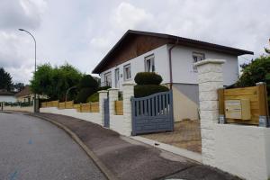 uma casa branca com um portão numa rua em Gîte Les Myrtilles Saint-Nabord, 5 personnes, 4 pièces avec garage em Saint-Nabord