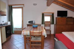 Bait da Sant'Antoni في ليفينو: مطبخ وغرفة طعام مع طاولة وسرير +10 صور