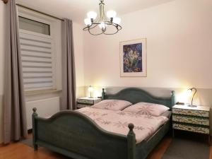 Un dormitorio con una cama con almohadas rosas y una lámpara de araña. en Kaiserliches Postamt Cobern en Kobern-Gondorf