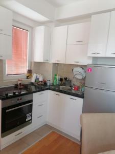une cuisine avec des armoires blanches et des comptoirs noirs dans l'établissement Luxury apartment Ohrid, à Ohrid
