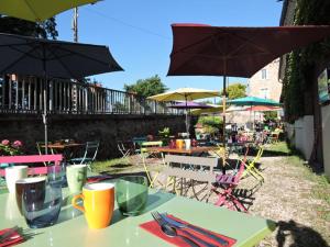 a table with chairs and tables with umbrellas at L auberge du lion d or in Nanteuil-sur-Marne