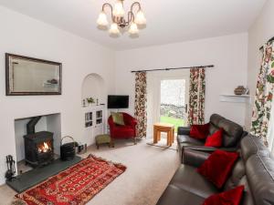 - un salon avec un canapé et une cheminée dans l'établissement Silverthwaite Cottage, à Ambleside