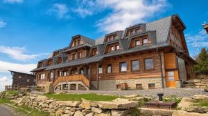 a large wooden house on top of a stone wall at Chata Emil Zatopek - Maraton - Lysa Hora in Krásná