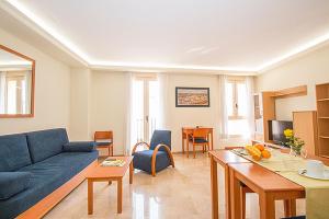 ein Wohnzimmer mit einem blauen Sofa und einem Tisch in der Unterkunft Viveros Apartments in Valencia