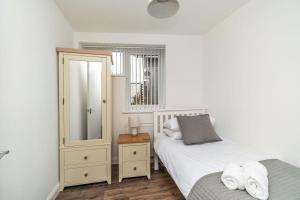 una camera con due letti, un comò e uno specchio di Sam's Cottage a Keswick